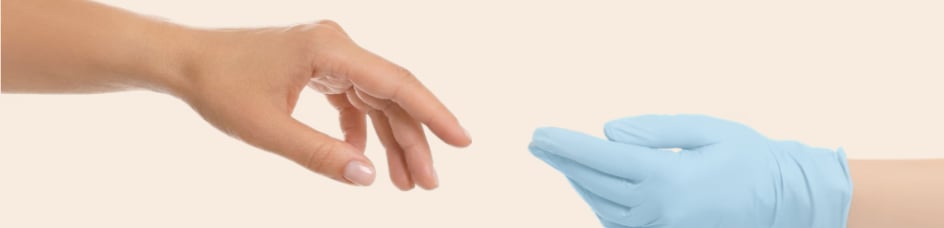 A bare hand reaching toward a gloved clinician hand